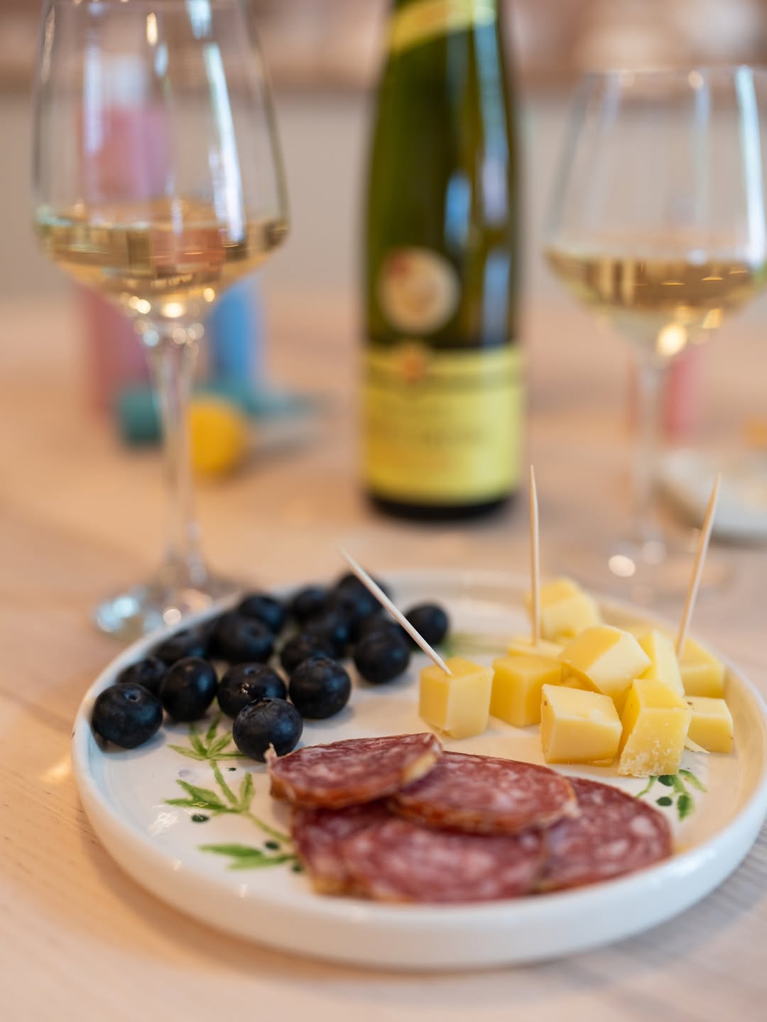 Zalogaji na keramičkom tanjuru uz čaše vina